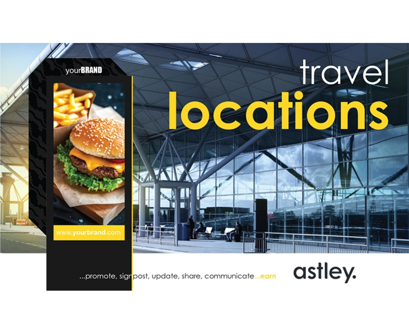 Digital advertisement at an airport showcasing a burger and fries from "yourBRAND" with website link "www.yourbrand.com". The text "travel locations" is prominently displayed in yellow and white against a background of modern airport architecture featuring large windows and steel beams. The brand "astley" is