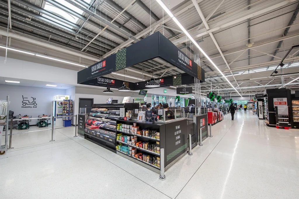A sushi bar with a variety of packaged sushi and snacks inside a large store.