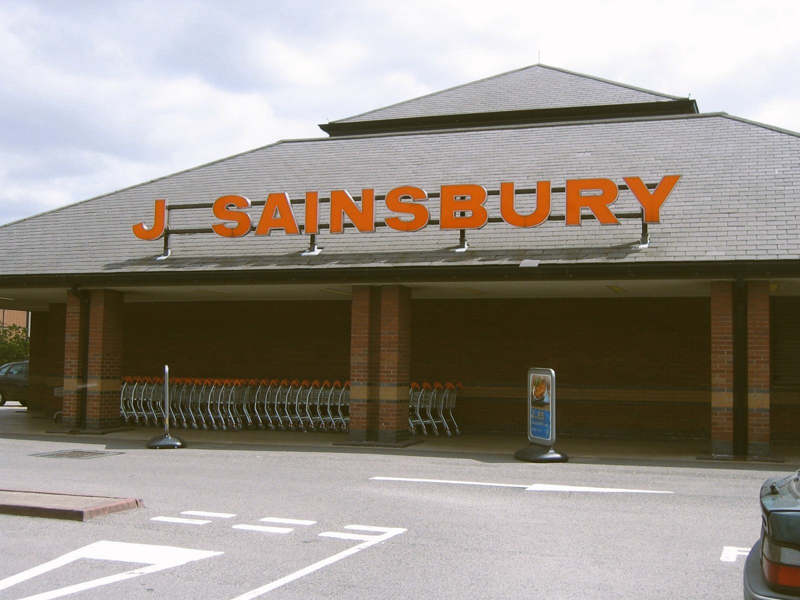 J Sainsbury storefront with shopping carts lined up in front of the entrance.
