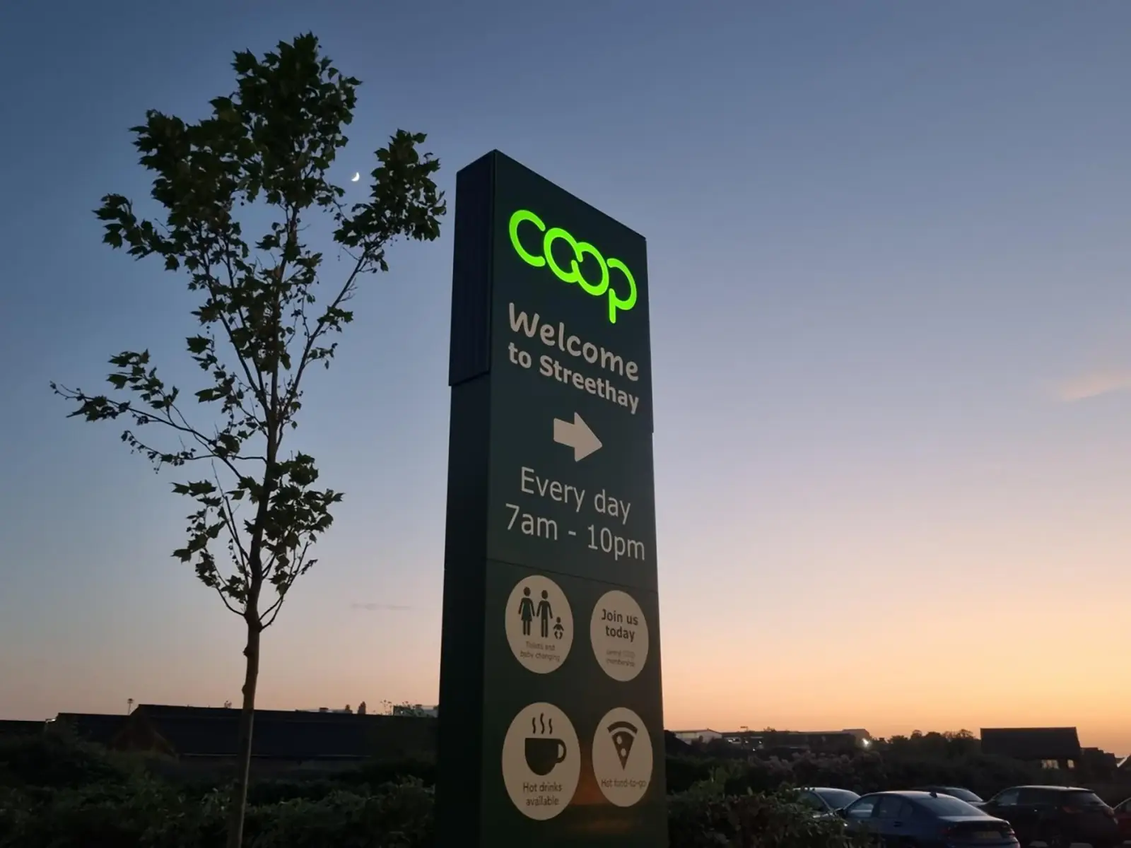 A Coop sign at dusk reads "Welcome to Streethay" with store hours and icons.