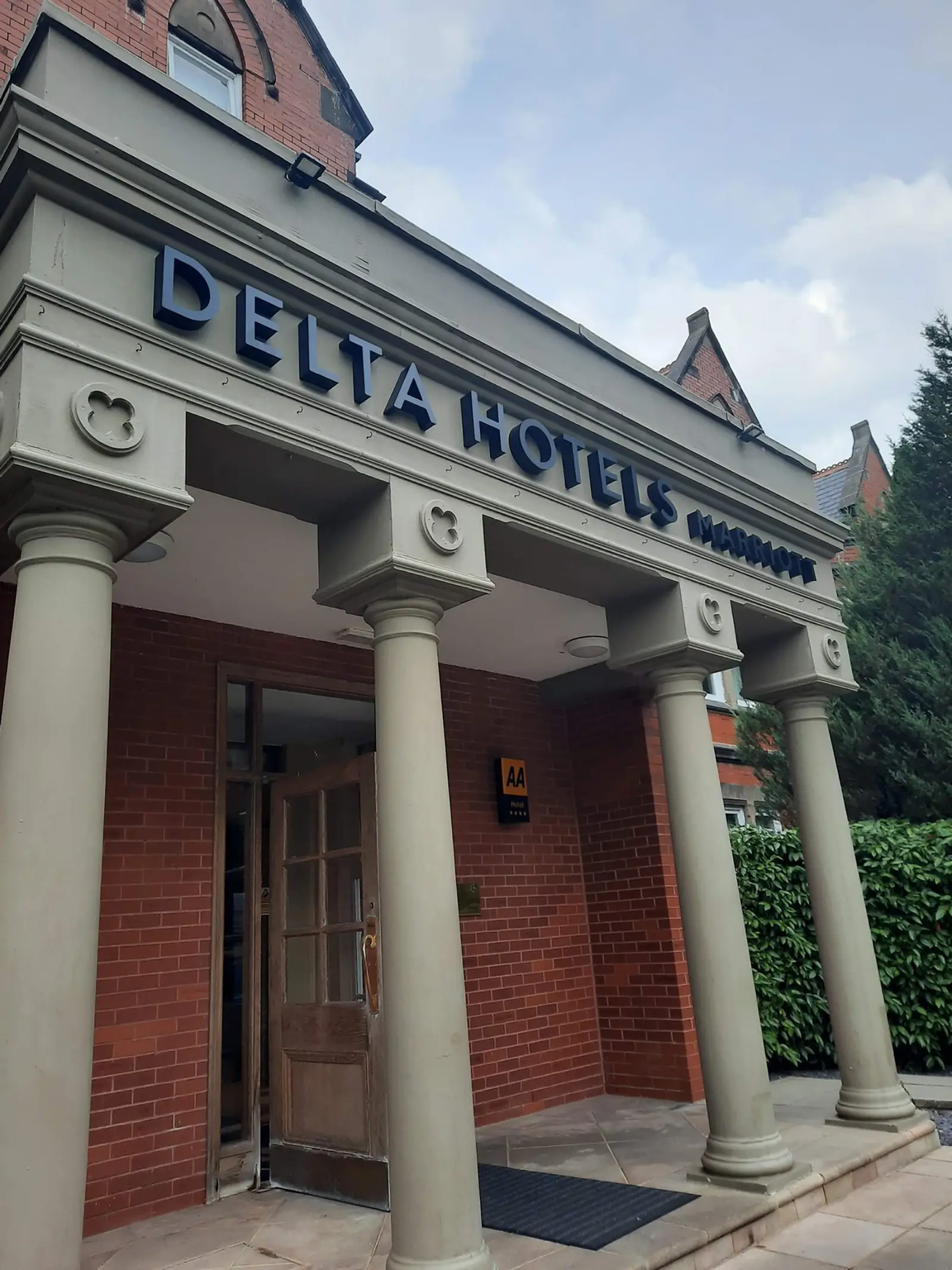 Entrance of Delta Hotels with columns and a brick facade.