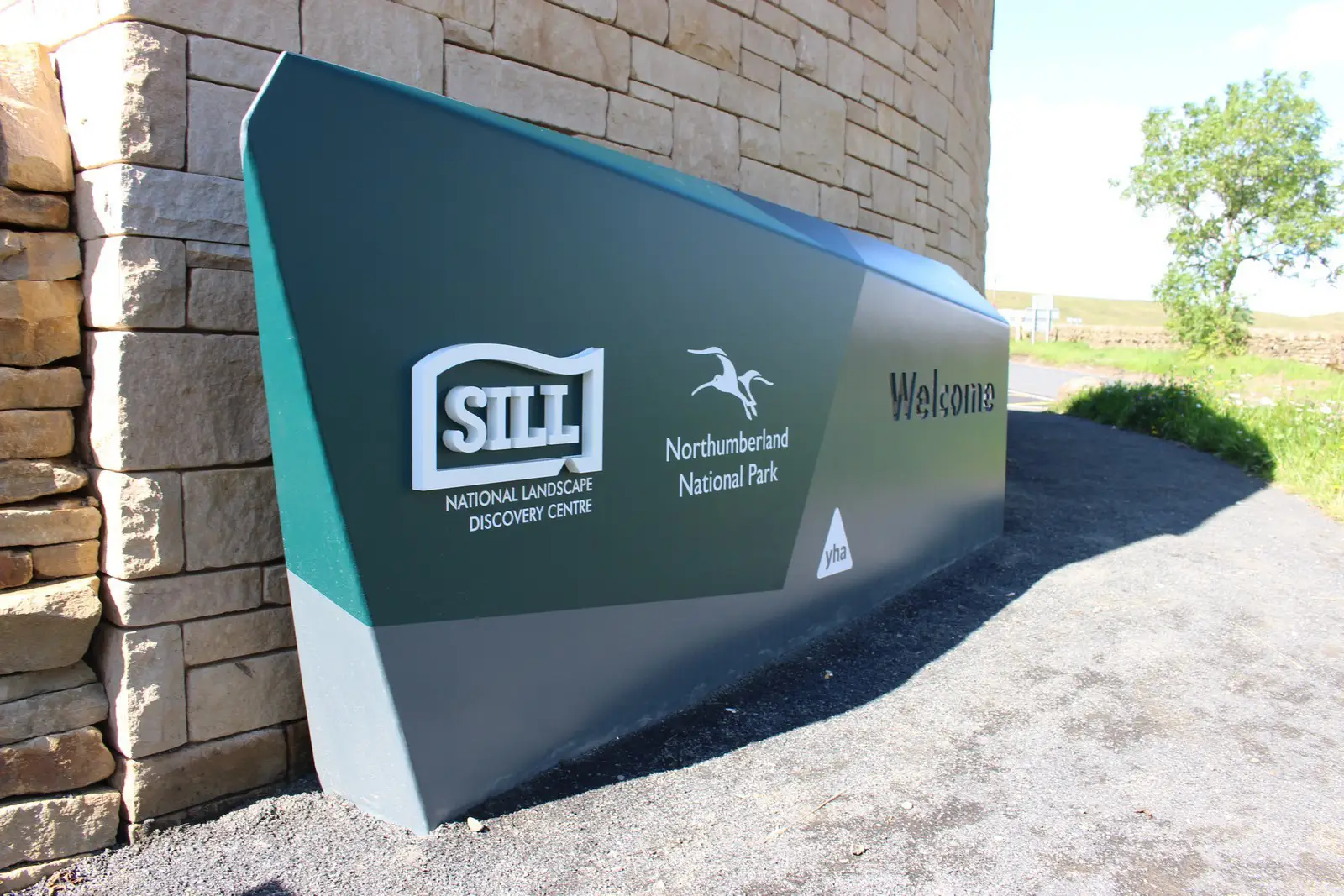 Large green sign for The Sill National Landscape Discovery Centre and Northumberland National Park.