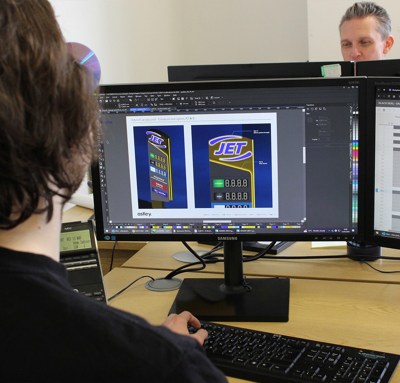 Person working on a computer with a design for a fuel price display on the screen.