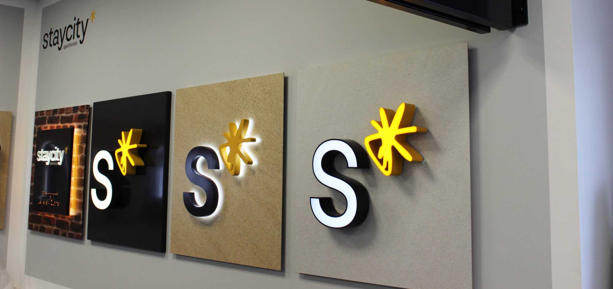 Four illuminated "S" logos with a yellow asterisk on different textured backgrounds.