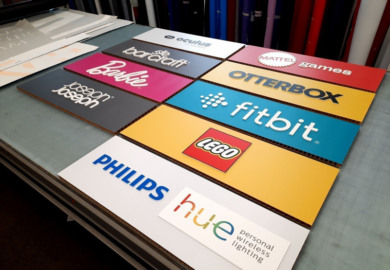 Nine colorful brand logos displayed on a table, including LEGO, Philips, and Barbie.