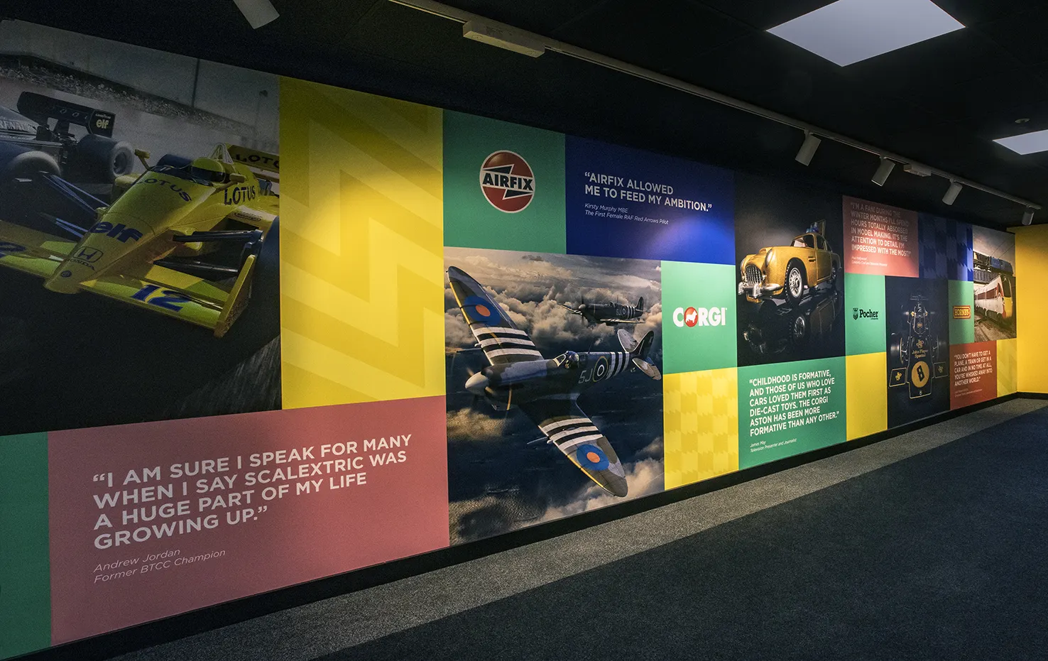 Colorful wall display featuring vintage cars, airplanes, and nostalgic quotes in a dimly lit room.