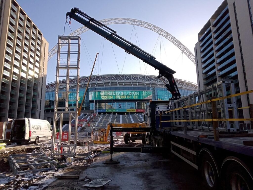 Astley totem sign manufacturer installing a structural steel totem frame by crane at Wembley Stadium
